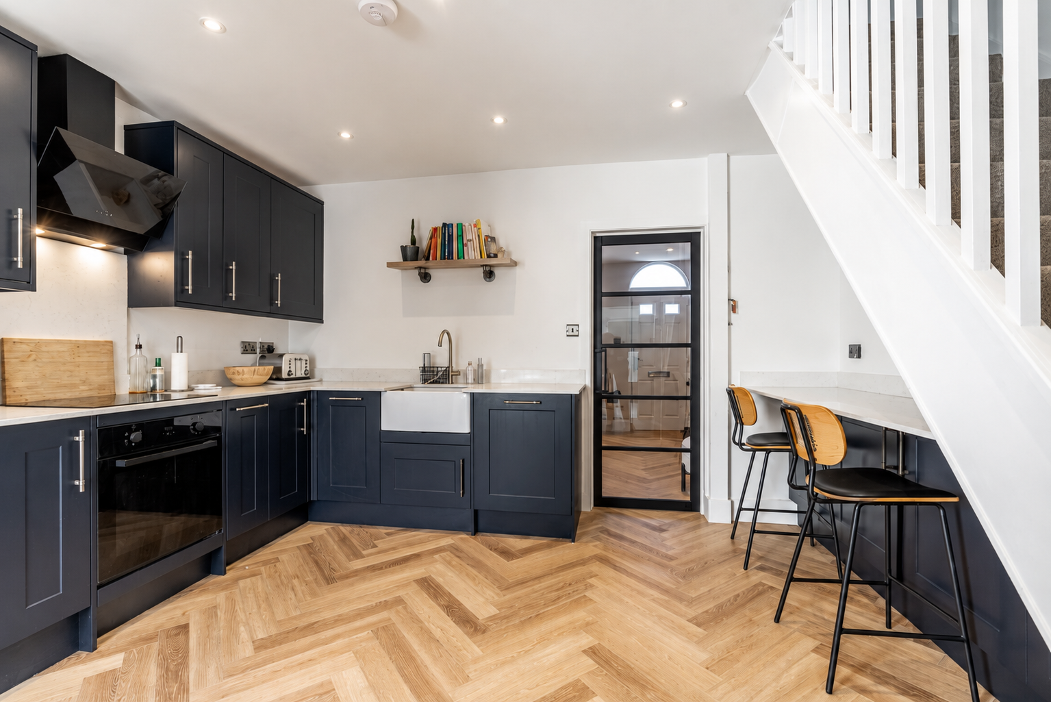 Navy shaker kitchen with herringbone flooring in an Oak managed property in North London